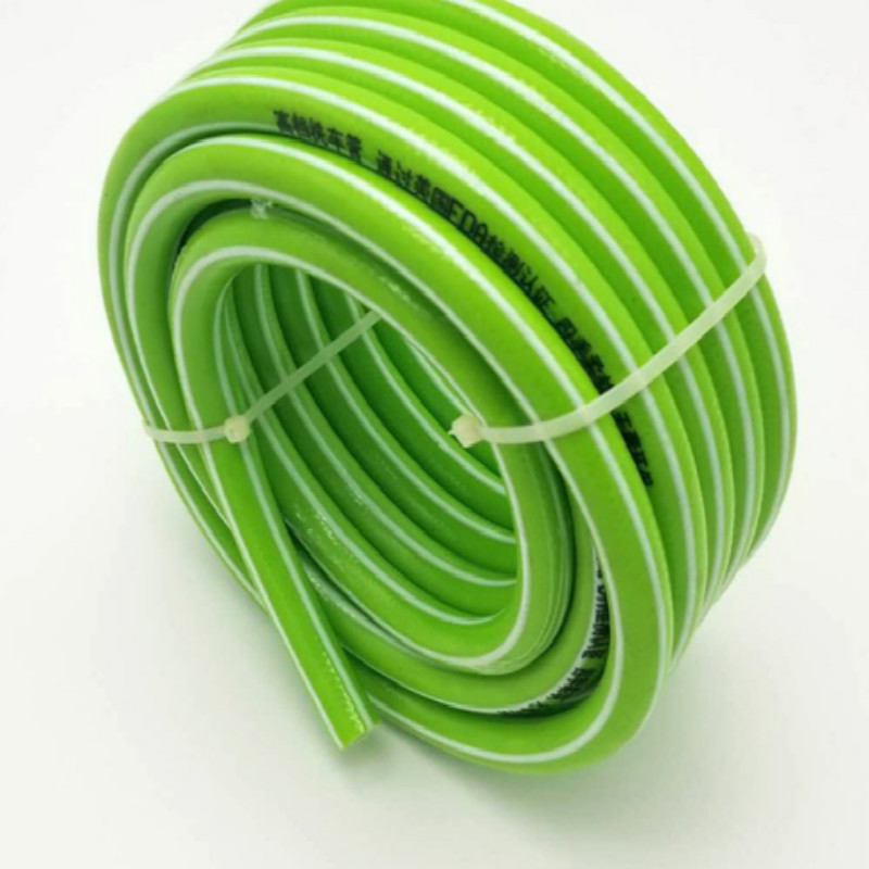 Farverig fleksibel fiberflettet armeret plastvandsslange i haven