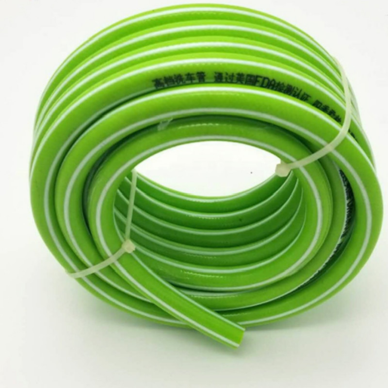 Farverig fleksibel fiberflettet armeret plastvandsslange i haven